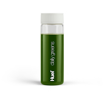 A bottle of Huel Daily Greens on a green powder background