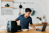 man using his laptop and air fryer in the kitchen