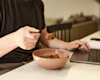 someone eating from a bowl whilst working on their laptop