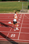 man running outside on a running track crossing the finish line