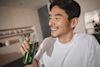 man drinking Huel Daily Greens from a Huel Bottle while smiling