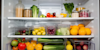 open fridge showing a variety of vibrant fresh vegetables and foods