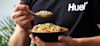 Man in Huel t-shirt eating Huel hot and savoury from a bowl