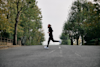russ cook running across a road with trees either side