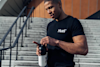 Man removing lid from Huel shaker whilst wearing a Huel t-shirt