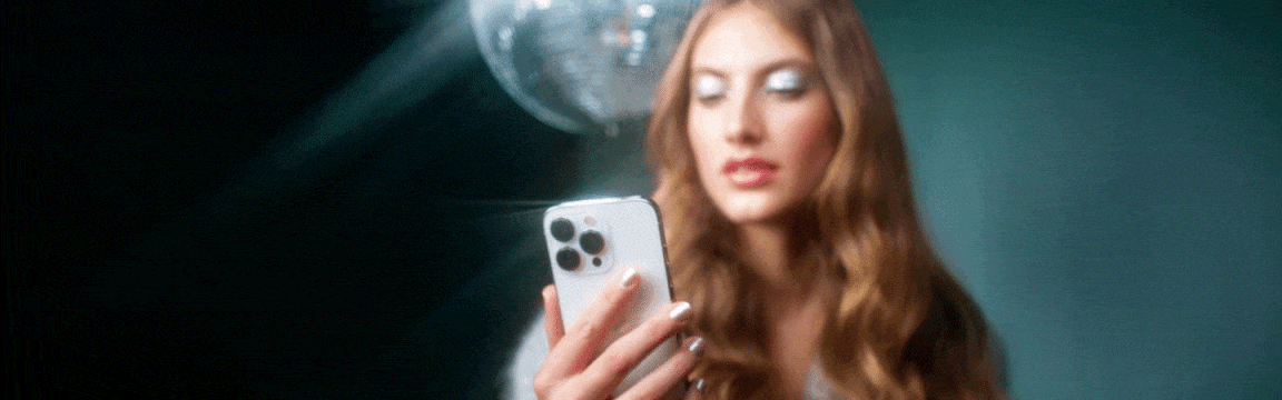 Videolla naisella on kädessään puhelin, jolla hän testaa AR-meikkifiltteriä. 