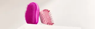 Pinkki ja vaaleanpunainen Tangle Teezer -harja.