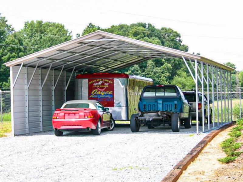 Steel carport sheltering vehicles and a trailer