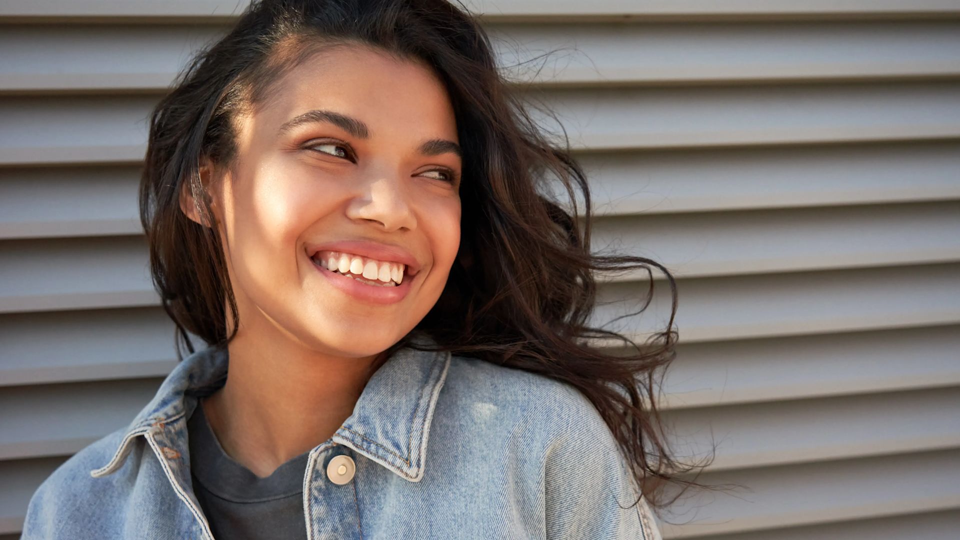 Une adolescente souriante regardant sur le côté.