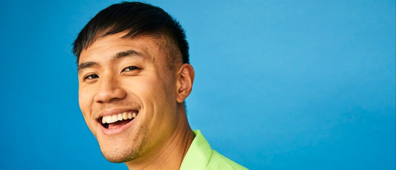 Jeune homme souriant portant une chemise verte
