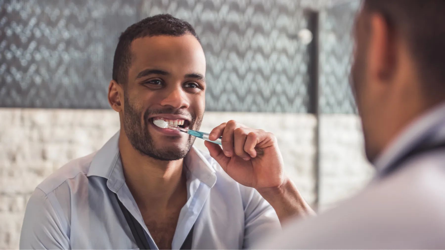 A mirror reflection of a man gently brushing your teeth, highlighting an oral care moment