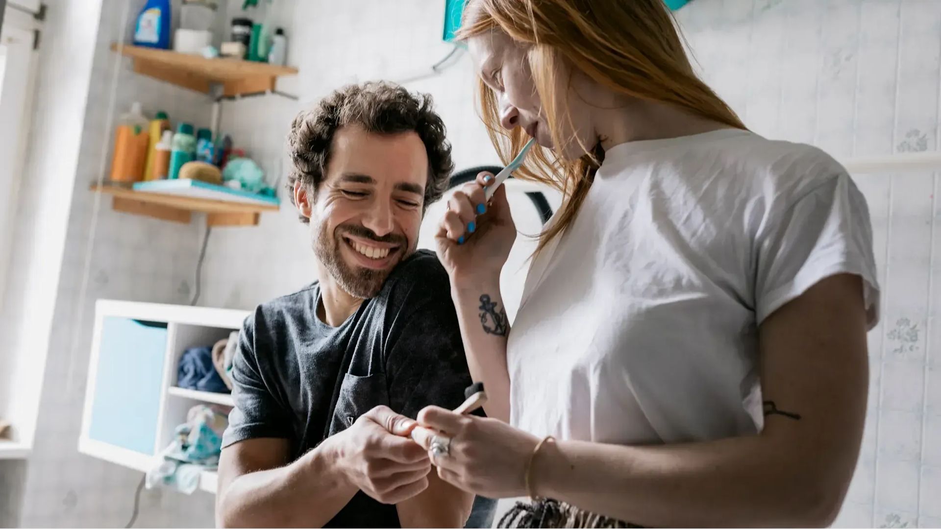 A couple having a relaxed and funny moment while brushing their teeth in the bathroom