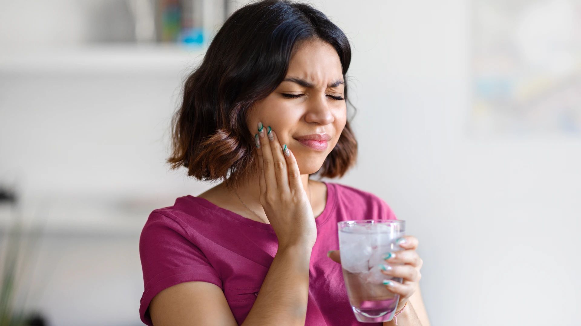 Woman grimacing with tooth pain