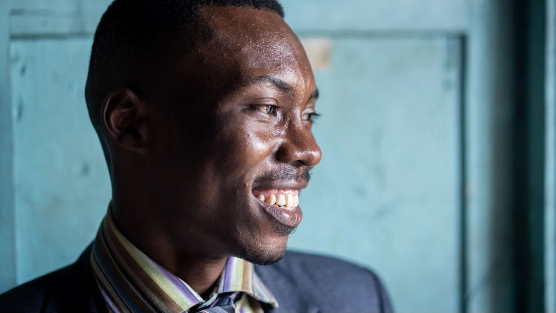 A smiling man wearing a suit and tie, exuding confidence and professionalism