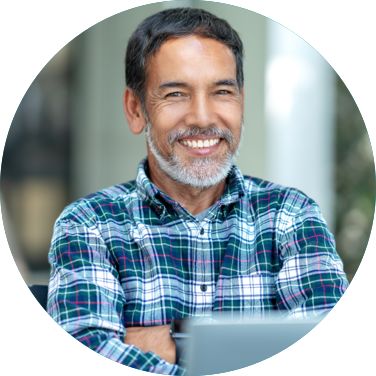 Man sitting outside with his laptop and smiling