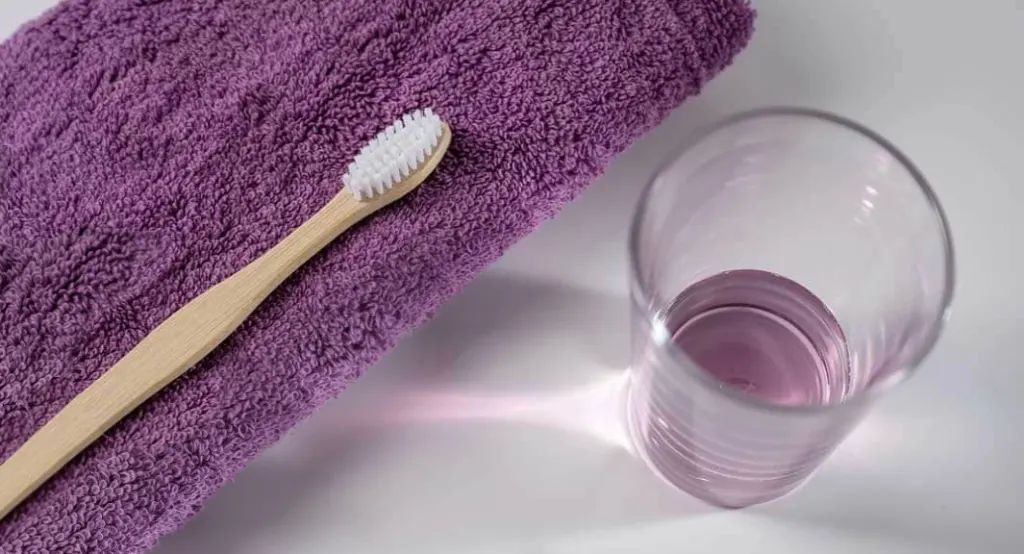 Listerine Oral Care Hero Banner featuring a toothbrush and mouthwash in purple contrast