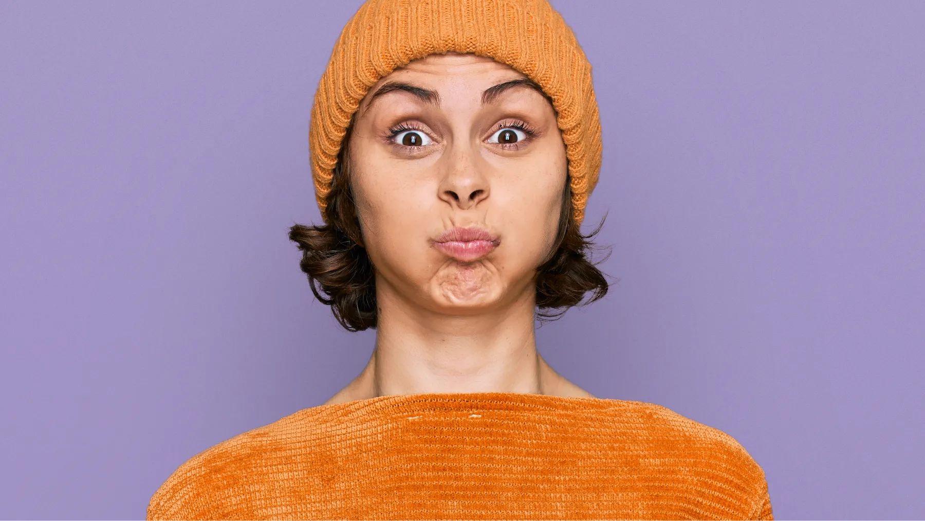 A woman puffs her cheeks as if she is using mouthwash hero for dry mouth and bad breath article