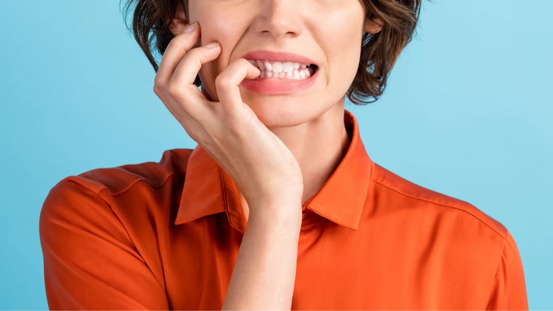 A woman thoughtfully resting her chin on her hand, displaying a pensive expression
