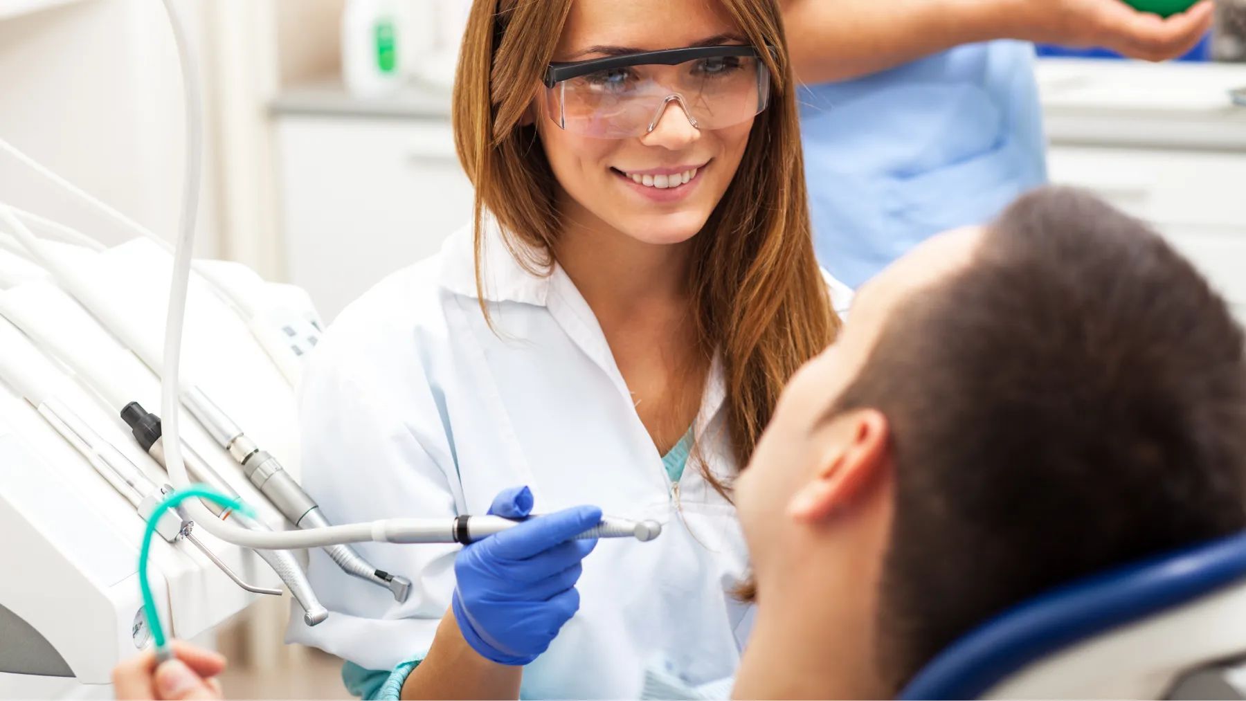 A cheerful female dentist is beginning a patient's dental treatment to catch cavities early