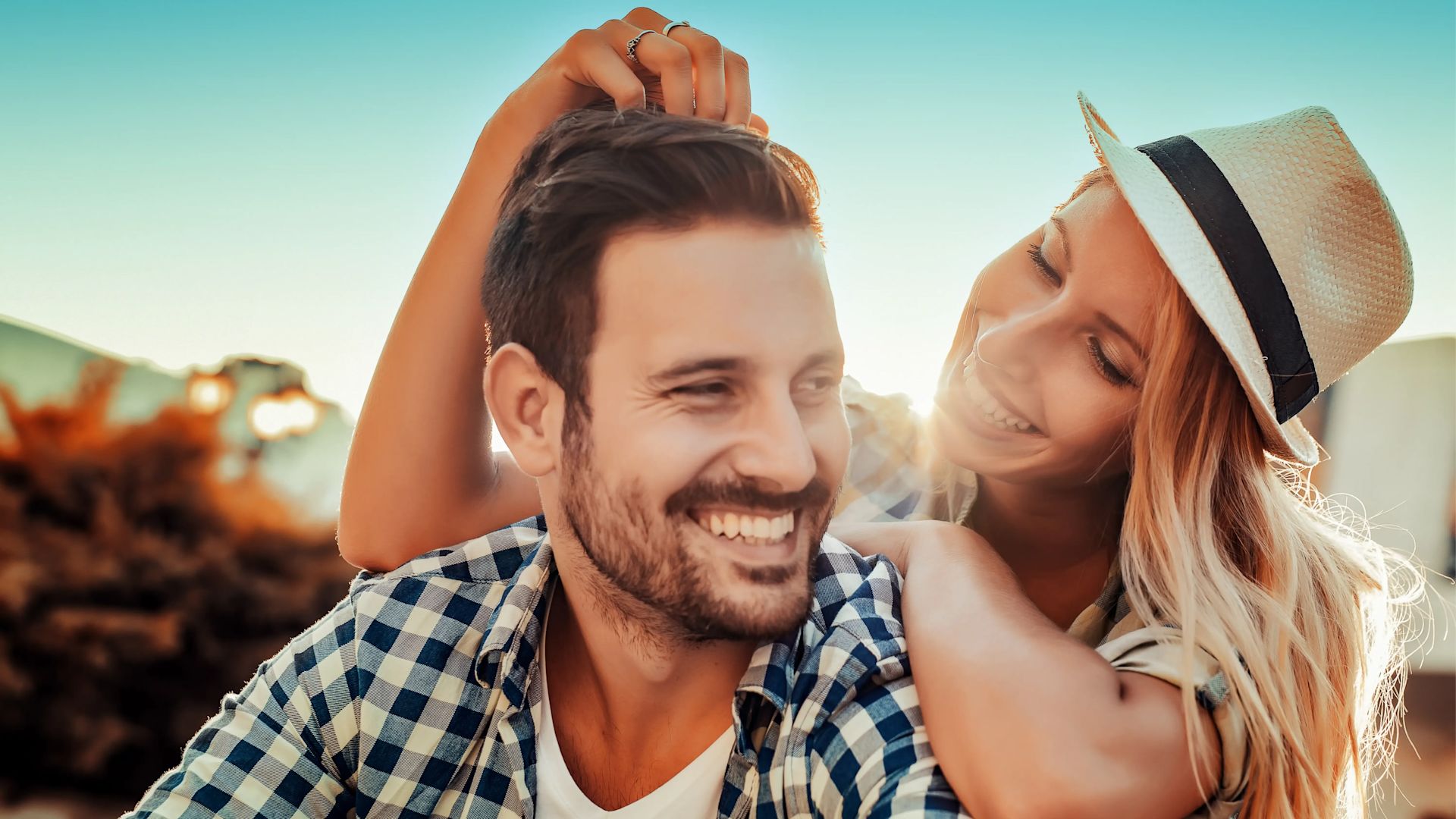 Un couple heureux avec une femme portant un chapeau.
