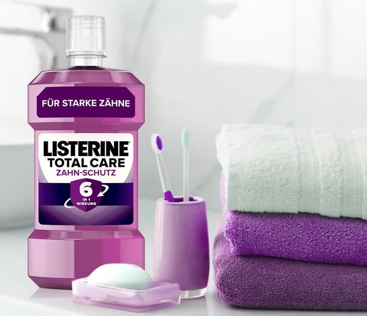Eine Listerine Packung, zwei Zahnbürsten und drei Handtüchern.