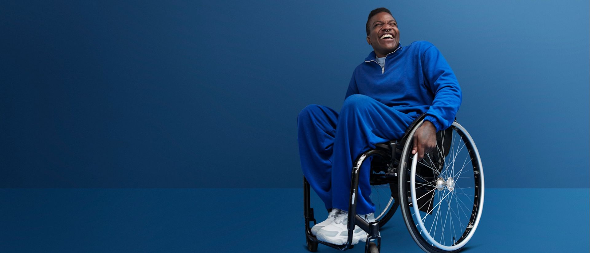 man in blue outfit sitting on a wheelchair and smiling | LISTERINE