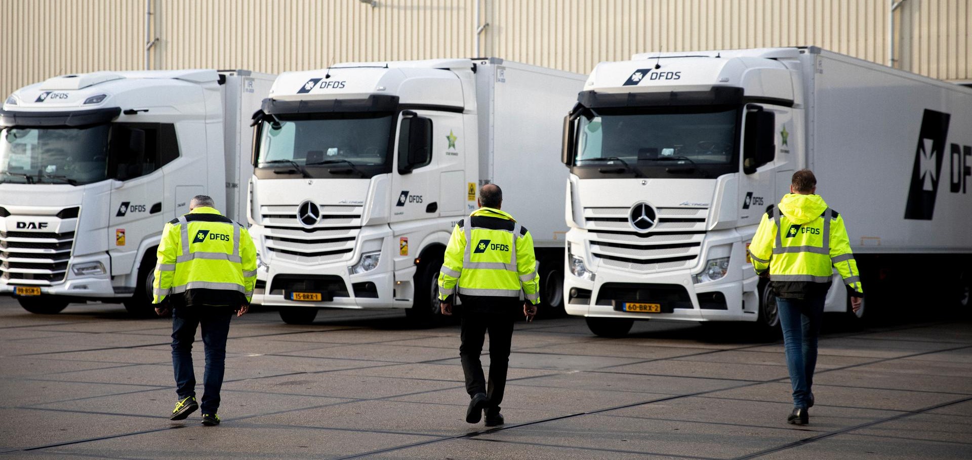 Drivers heading to their trucks outside a warehouse.