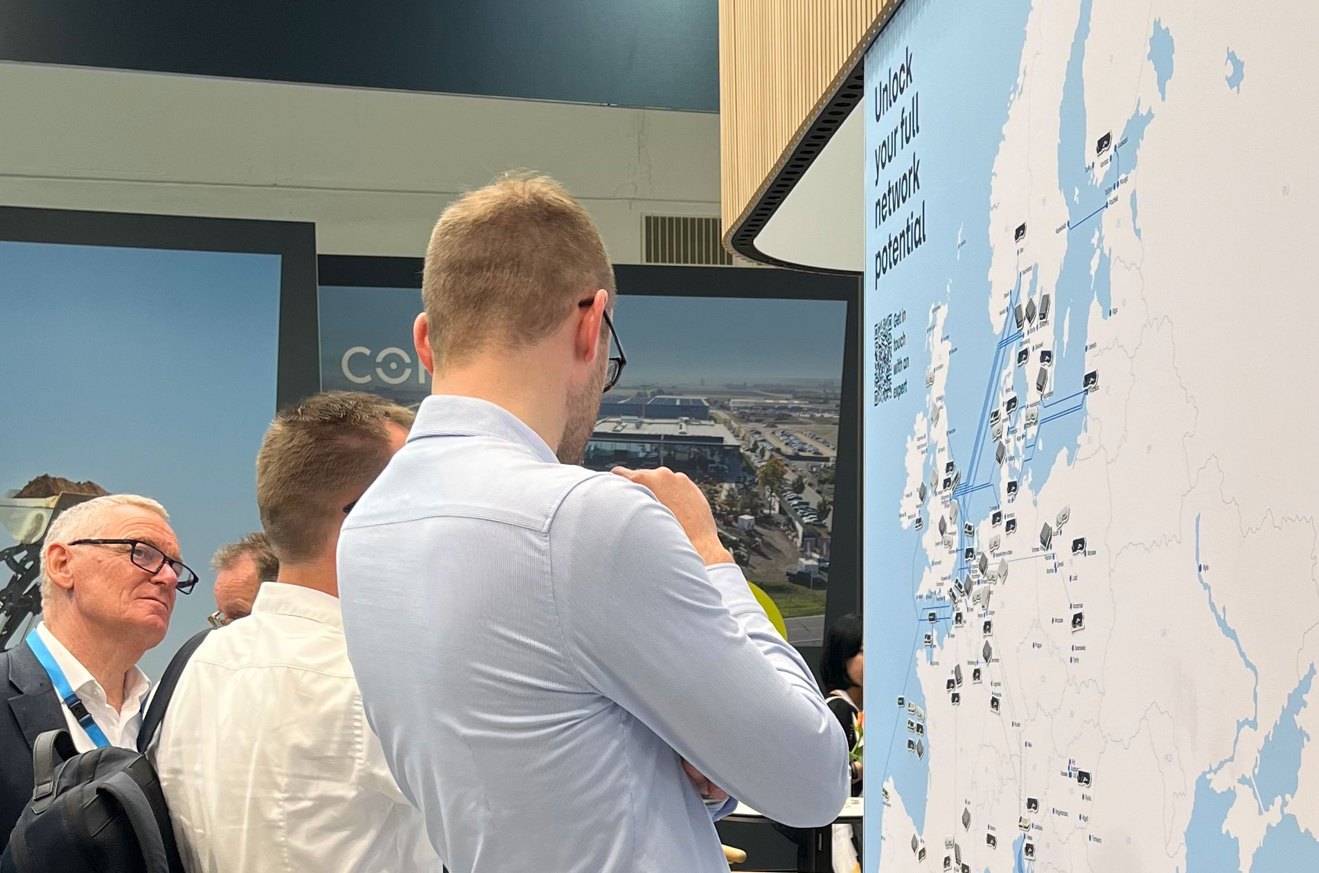 Münih fuar standında DFDS müşterisi, mıknatıslı rota haritasına genel bakışı inceliyor.