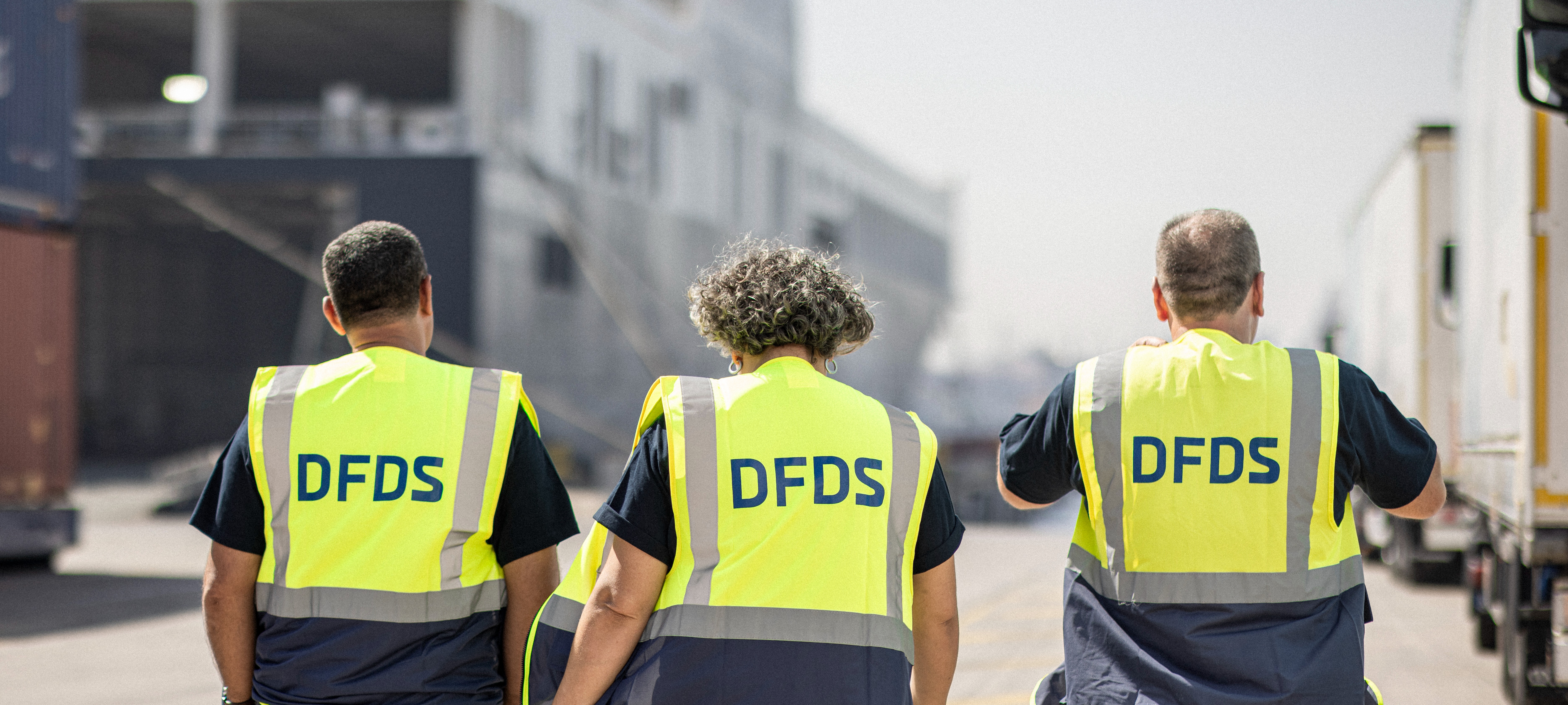 Trois salariés DFDS qui avancent, regard sur l'horizon, vus de dos