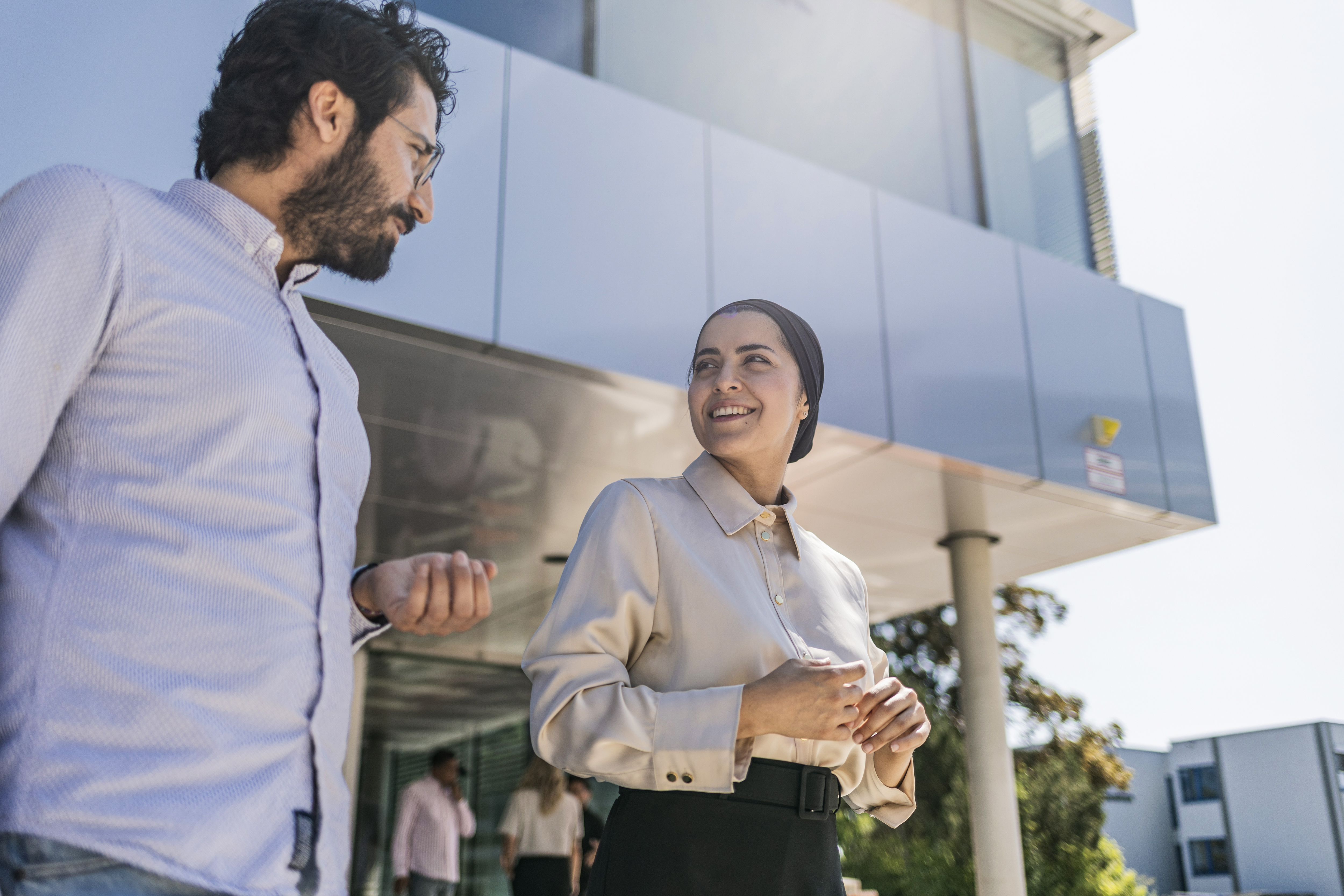 Ein Mann und eine Frau unterhalten sich vor dem Gebäude