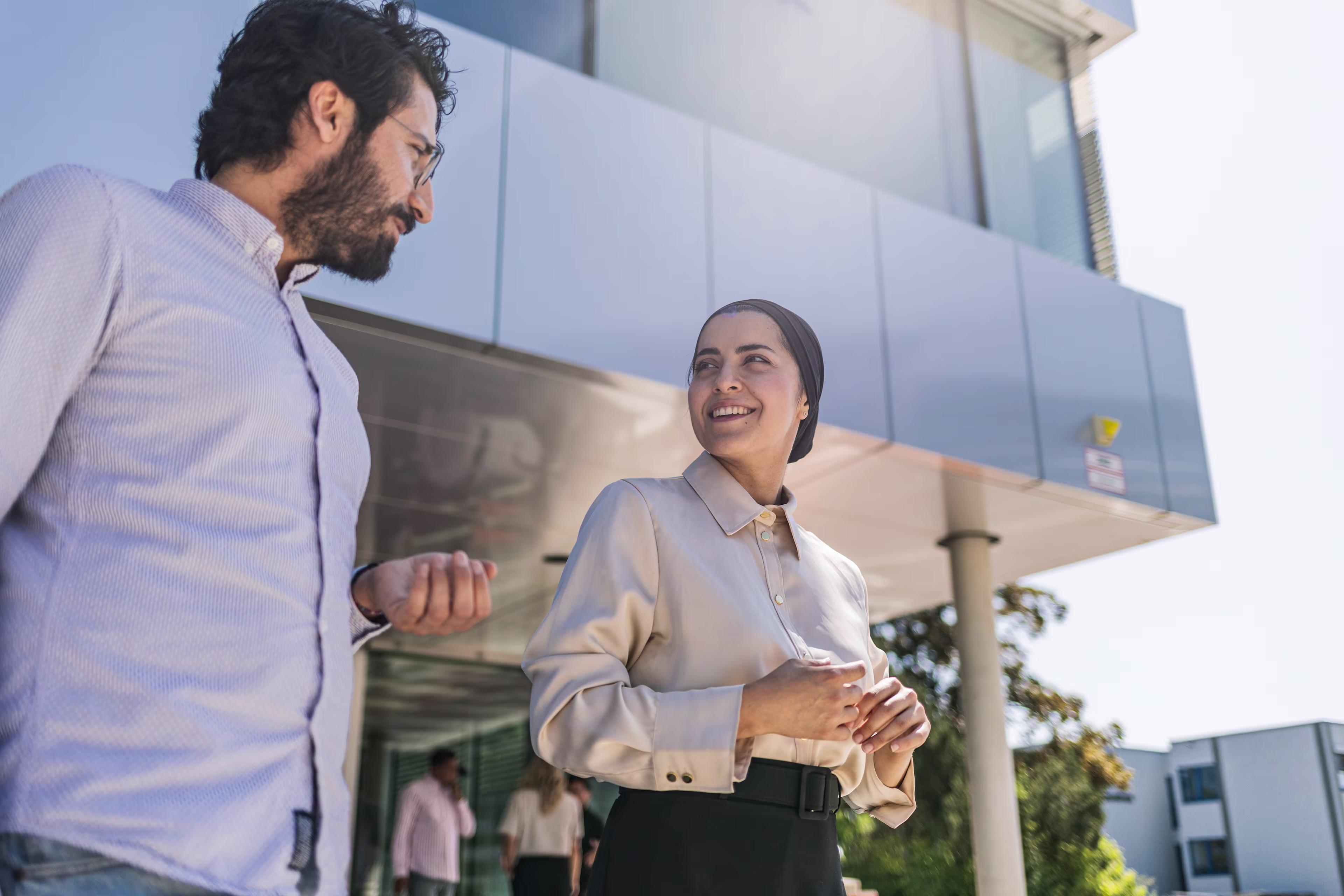 Ein Mann und eine Frau unterhalten sich vor dem Gebäude