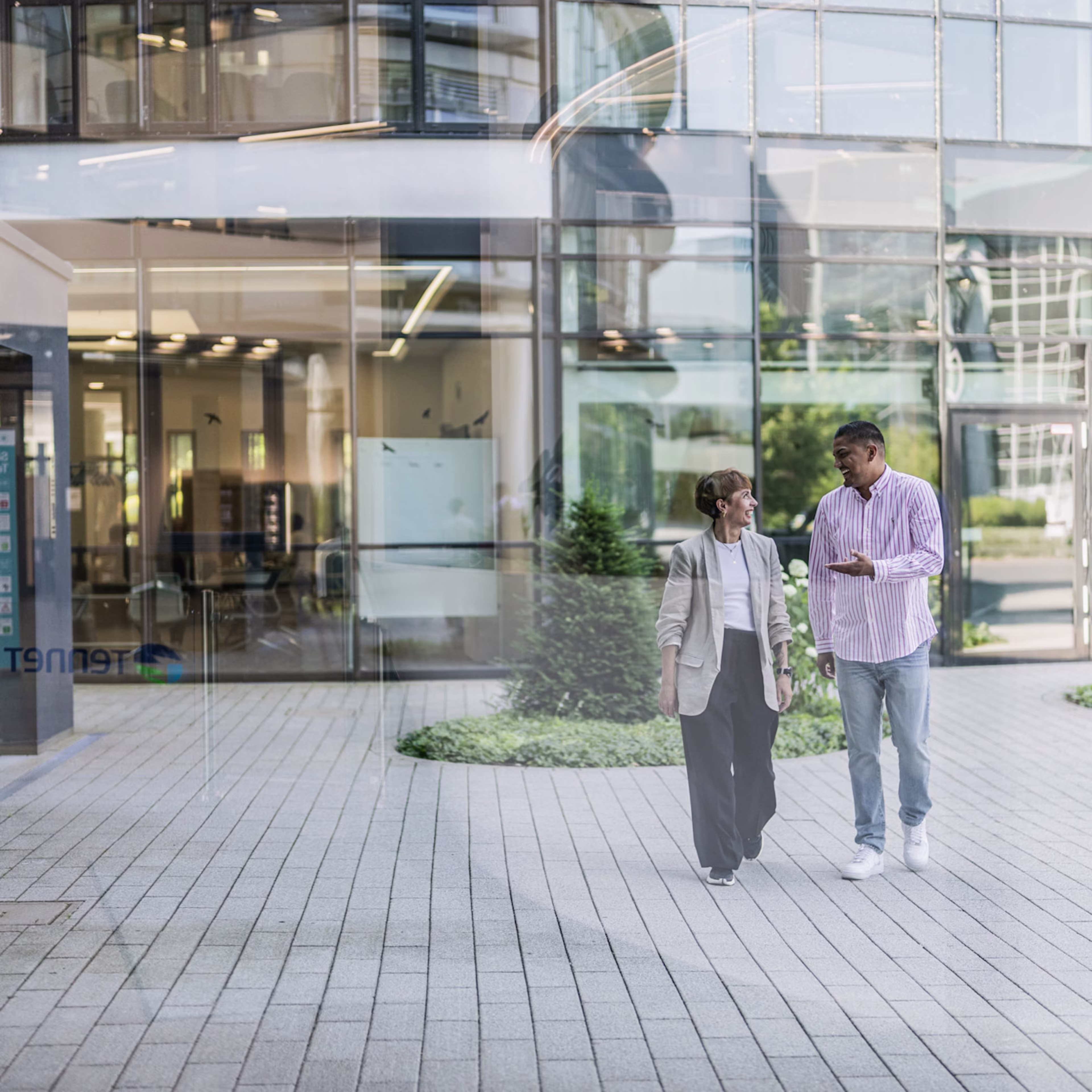 Zwei Frauen stehen vor dem TenneT Firmengebäude
