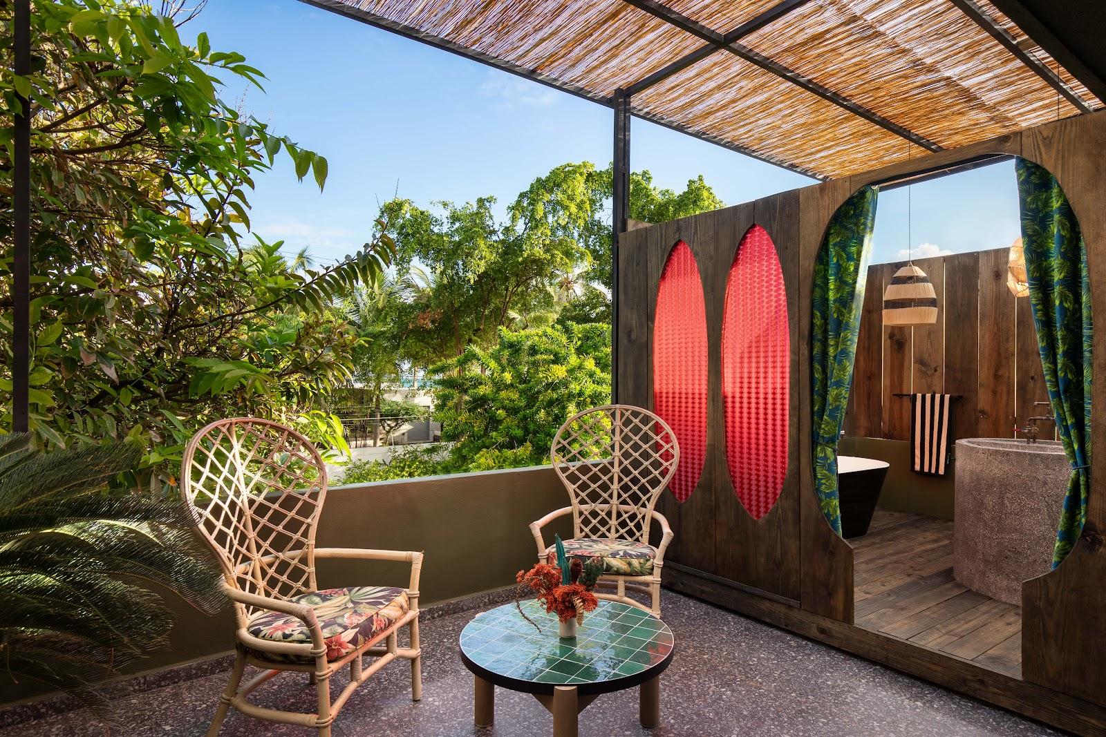 A private terrace with rattan chairs at Dreamcatcher, the flagship boutique hotel of Dreamers Welcome, looking over Ocean Park's palms.