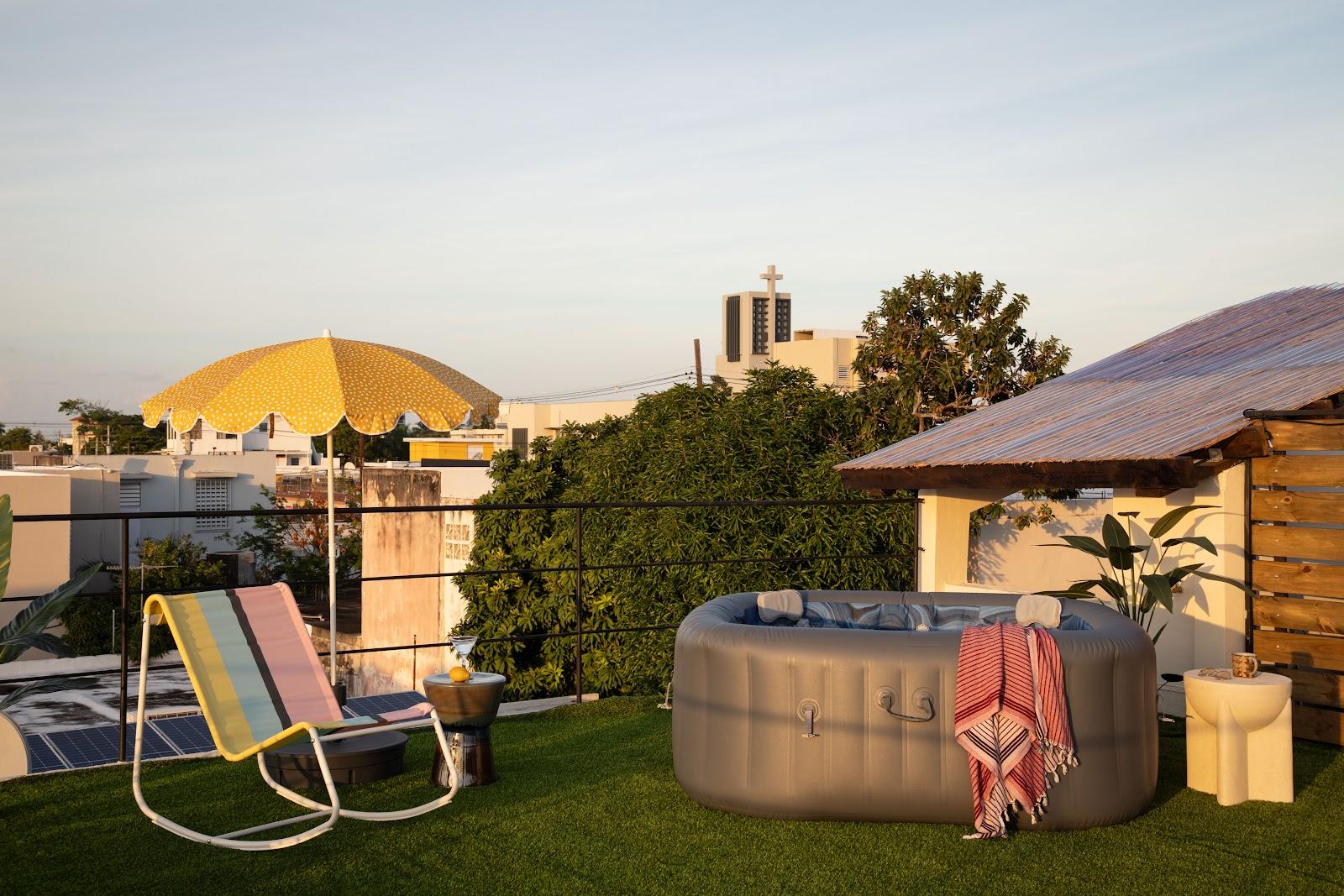 The rooftop deck and hot tub at Noa by DW, a Dreamers Welcome apartment stay in San Juan, at dusk.