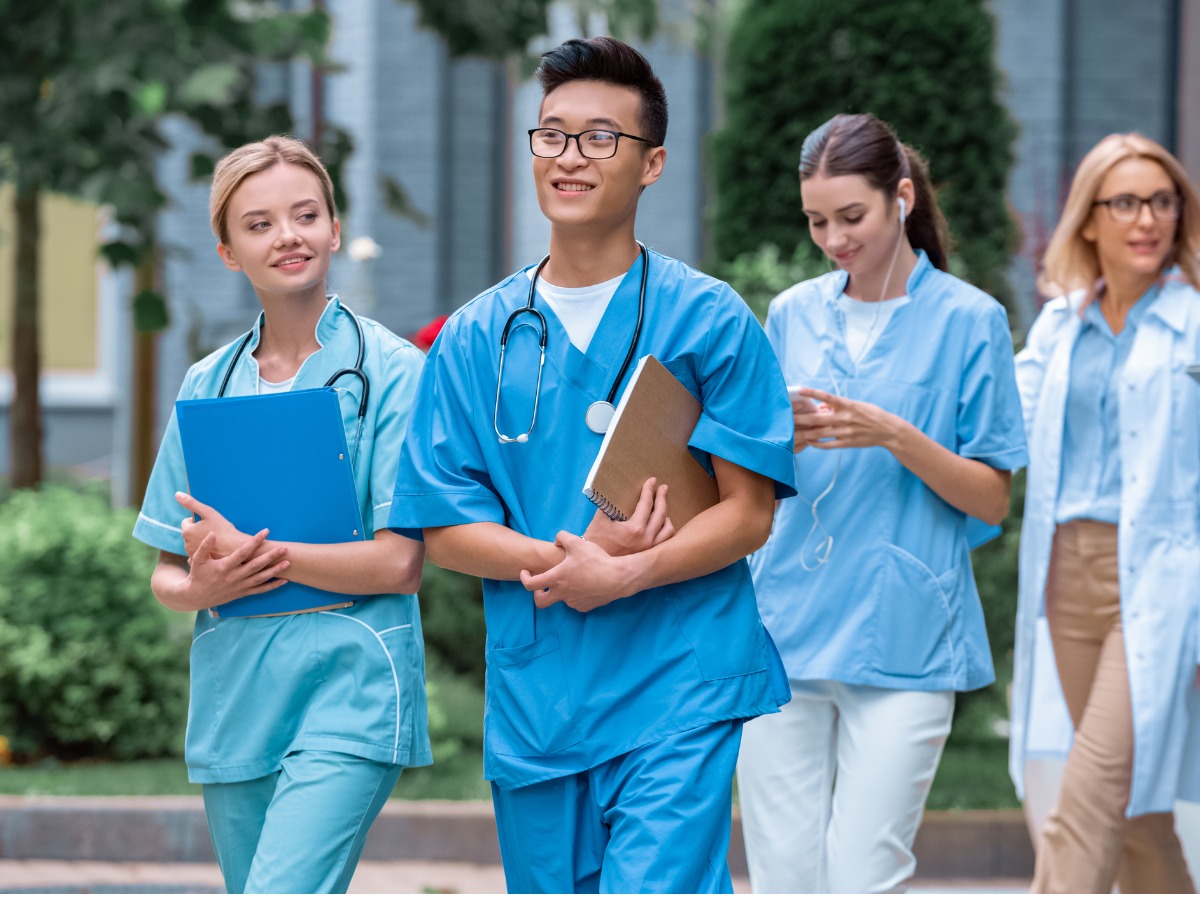 multicultural-students-and-teacher-walking-on-street-near-medical-picture-id1010601644