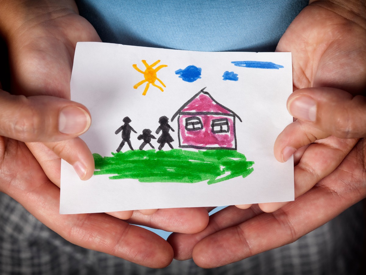 child-and-his-mom-holding-a-drawn-house-with-family-picture-id515240078