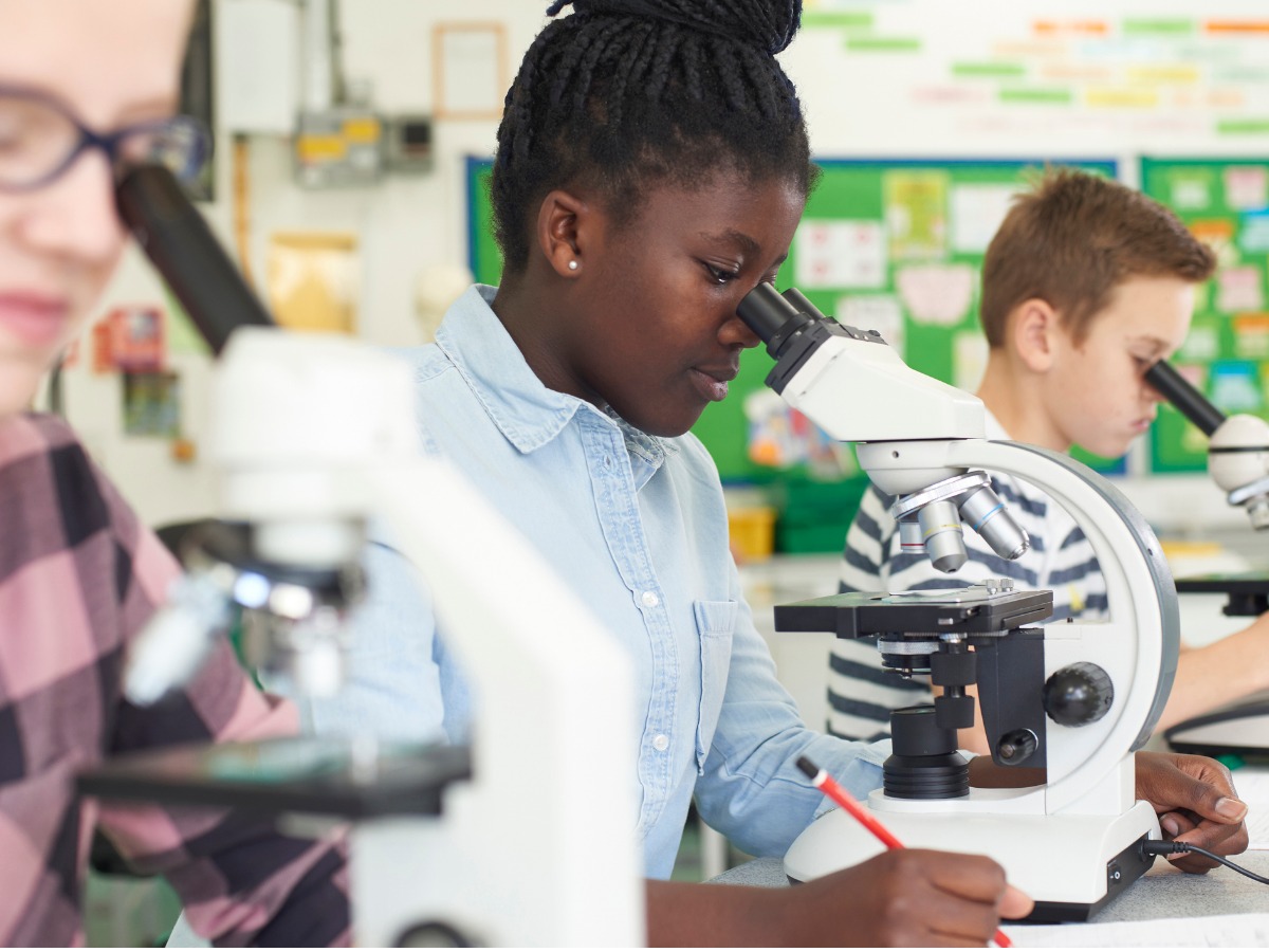 group-of-pupils-using-microscopes-in-science-class-picture-id875575532