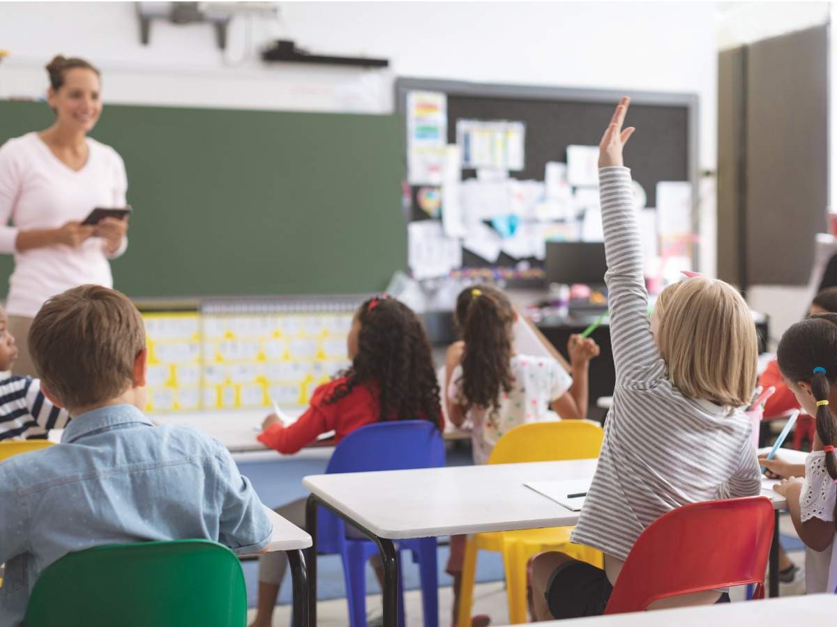 caucasian-schoolgirl-raising-hand-with-his-classmates-surround-of-her-picture-id1138365947