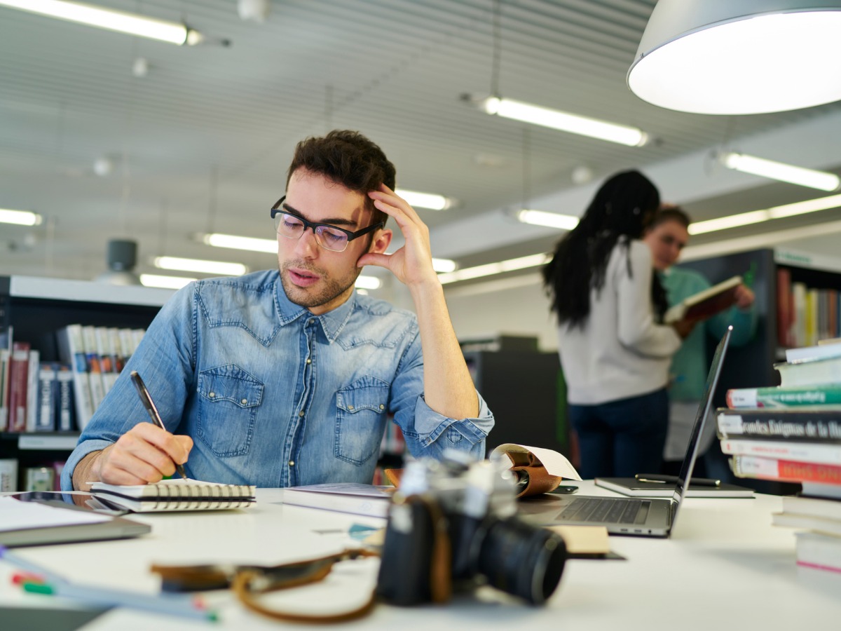 concentrated-male-student-in-eyeglasses-thinking-about-new-thesis-for-picture-id903981606