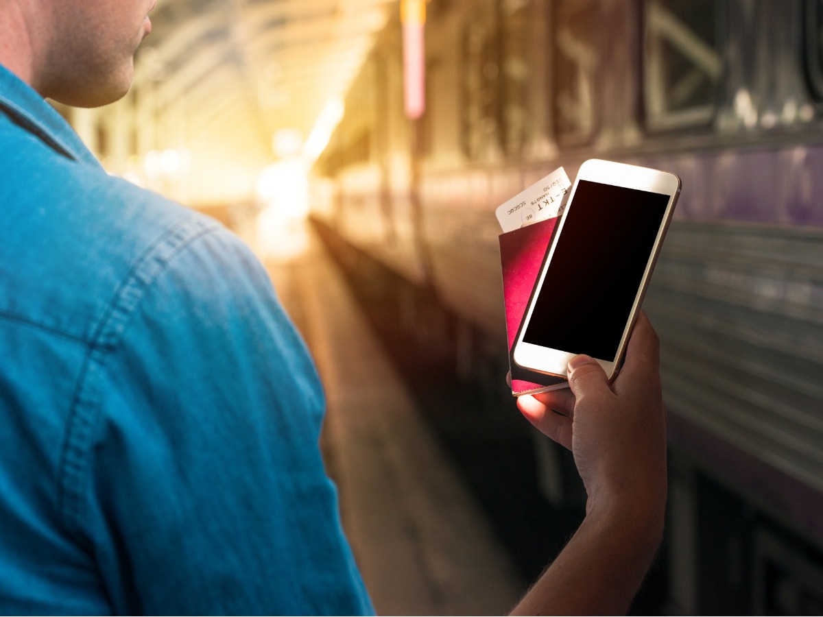 man-holding-passport-and-smart-phone-with-blank-waiting-in-a-train-picture-id905998738