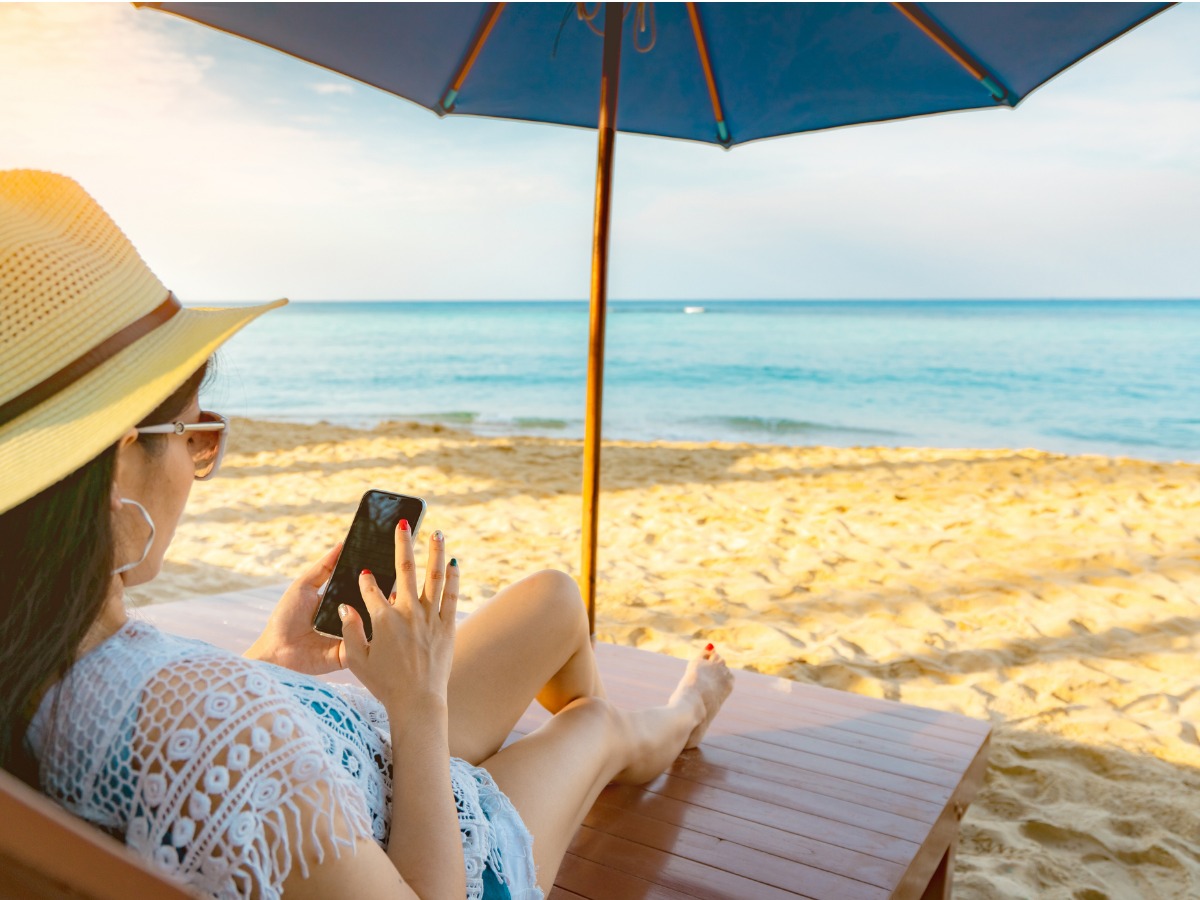 asian-woman-with-hat-sit-on-sunbed-under-beach-umbrella-at-sand-beach-picture-id1131702061