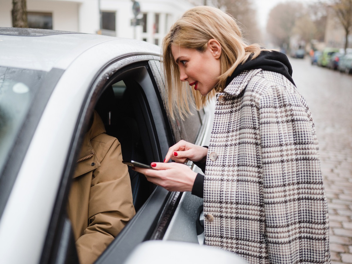 tourist-woman-talking-to-an-uber-driver-picture-id1206819388