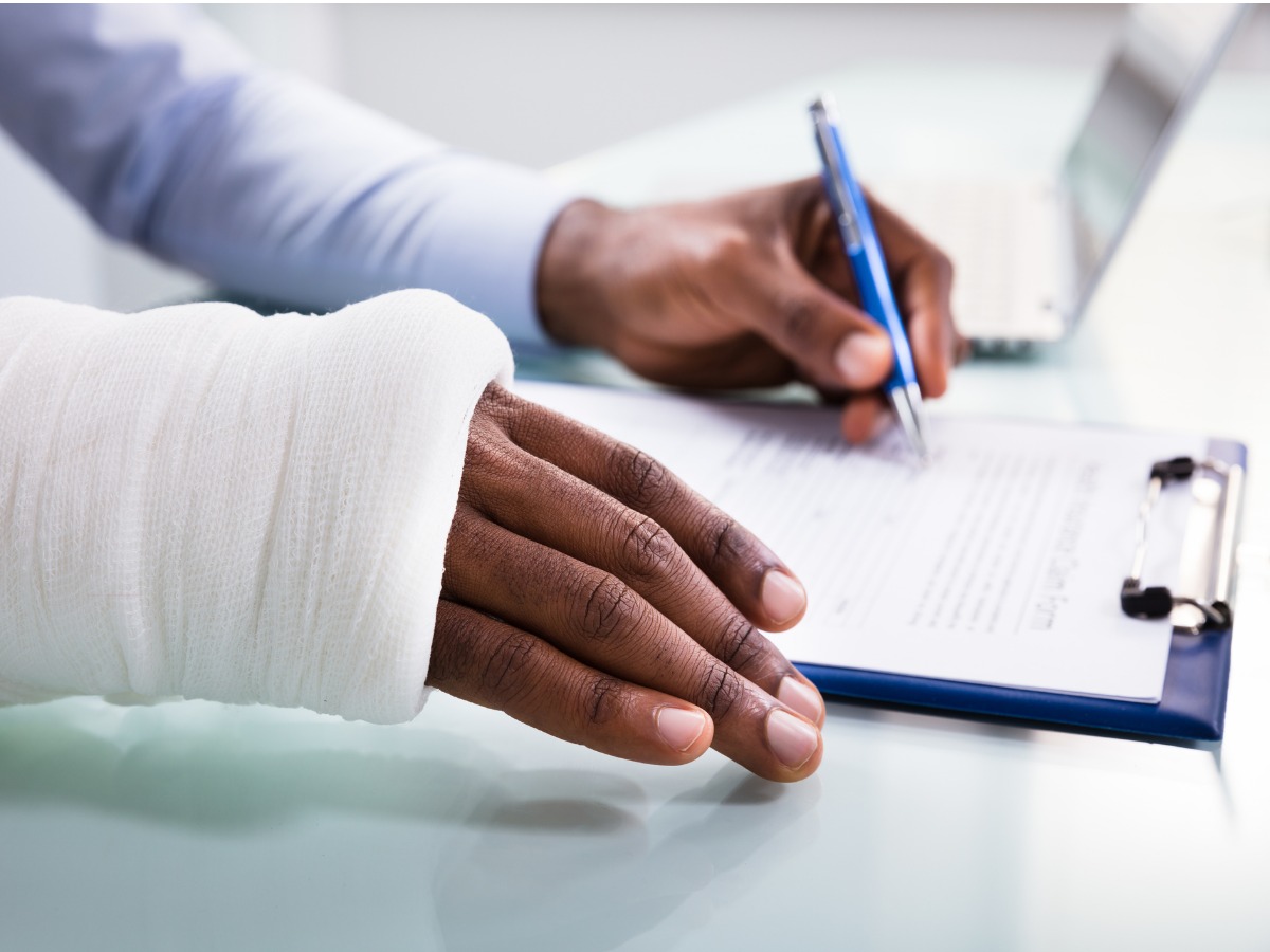 injured-man-filling-insurance-claim-form-picture-id1000962706