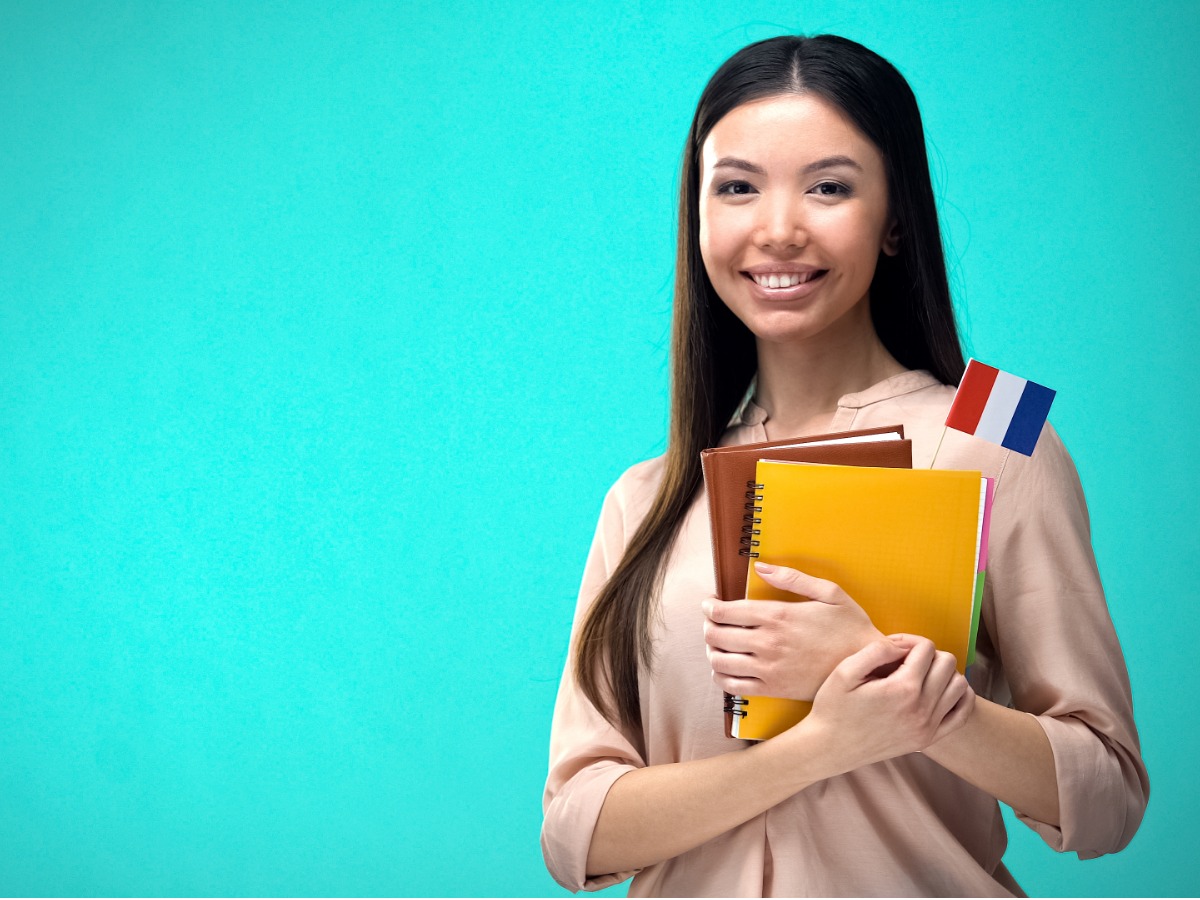 cheerful-woman-holding-french-flag-book-education-abroad-learning-picture-id1169984673