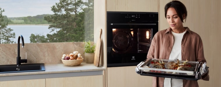 Woman carrying a beautiful tray of food to cook in her oven