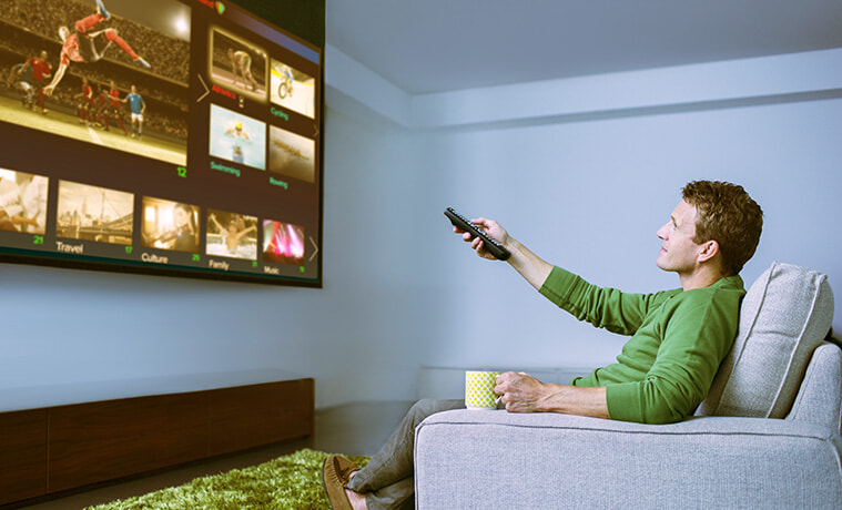 Man watching sports on a big screen TV in his media room