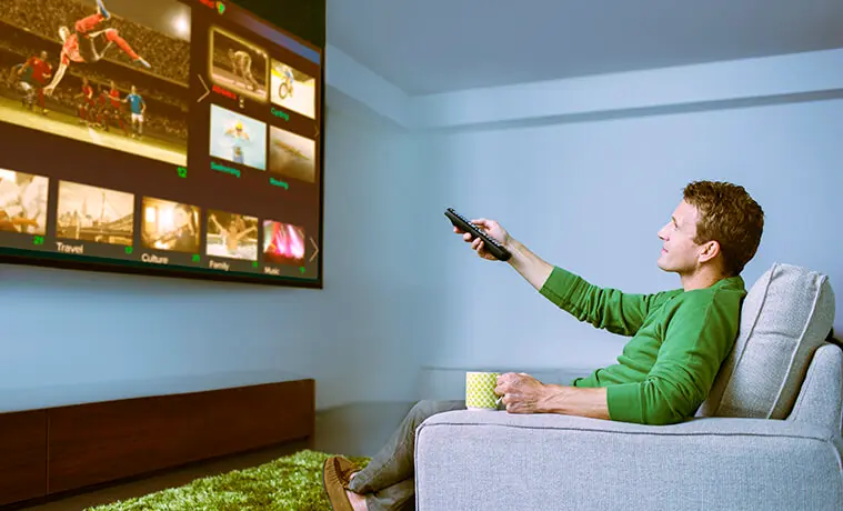 Man watching sports on a big screen TV in his media room