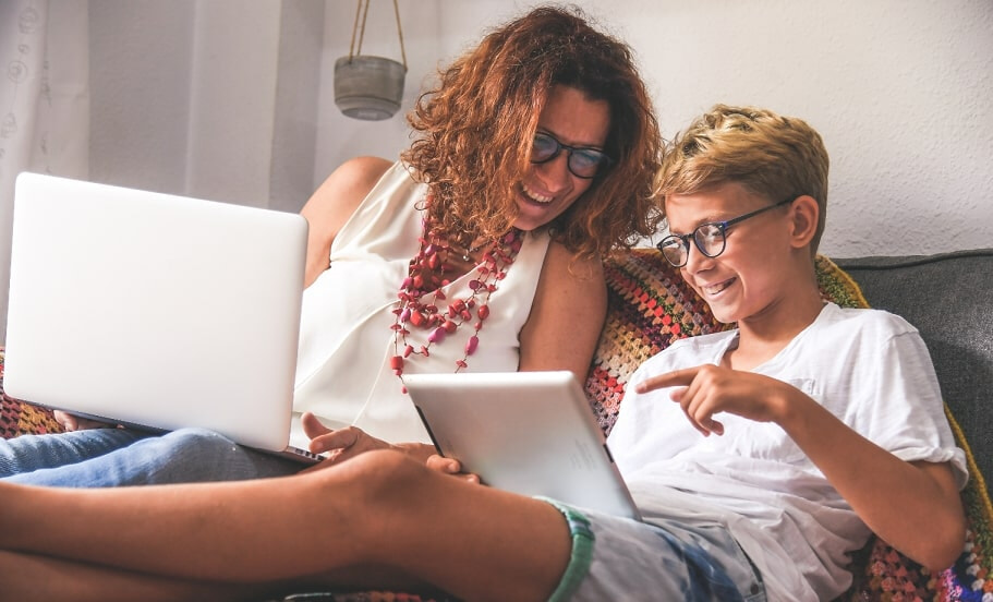 A parent and child using laptops together 