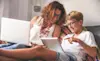 A parent and child using laptops together 