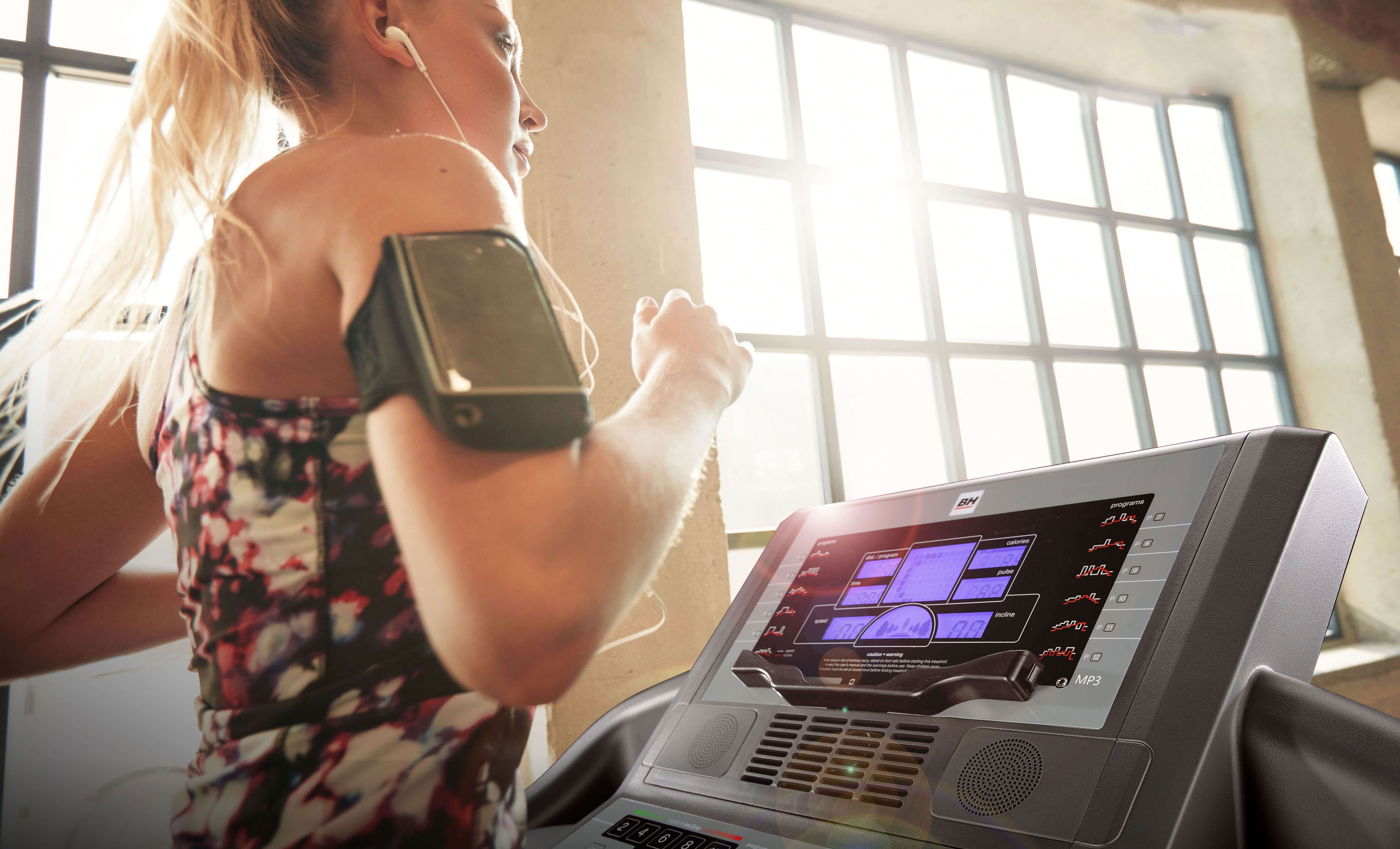 A woman runs on a treadmill at home